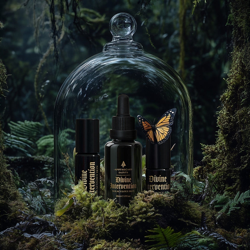 Divine Intervention face oil in a glass bell jar surrounded by moss and foliage