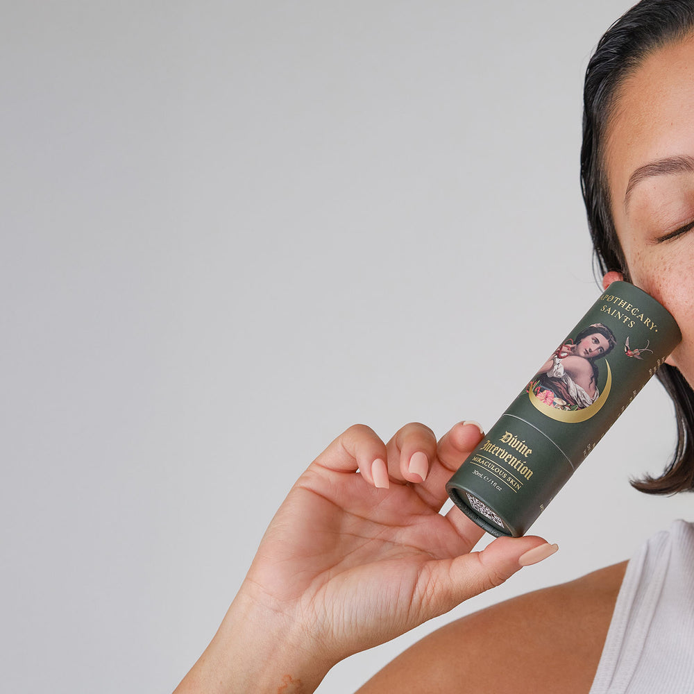 Woman holding Divine Intervention face oil packaging