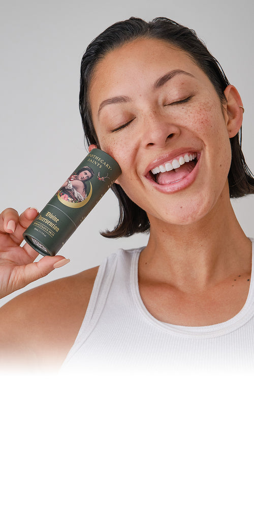 Model holding Divine Intervention face oil packaging