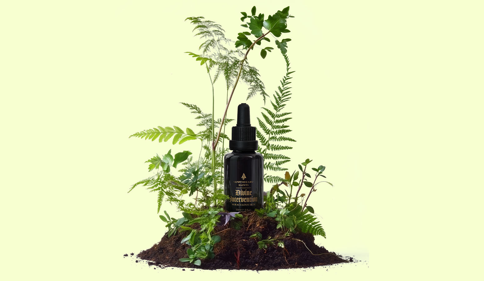 bottle of divine intervention face oil in mound of dirt with plants growing around