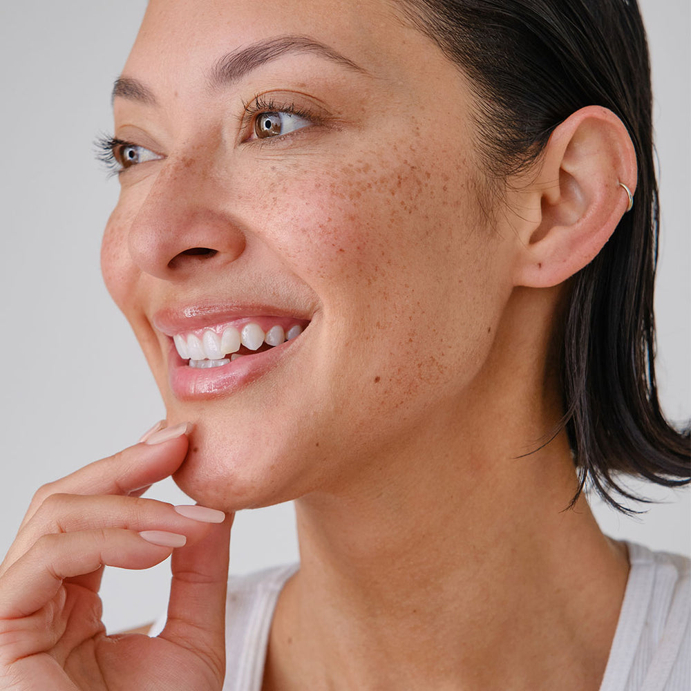 Profile of woman smiling, showing glowing skin after using face oil